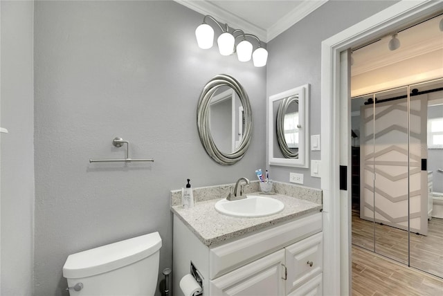 bathroom featuring vanity, crown molding, toilet, and hardwood / wood-style flooring