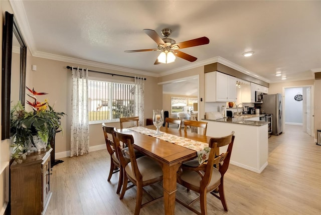 dining room featuring crown molding, light hardwood / wood-style floors, sink, and ceiling fan