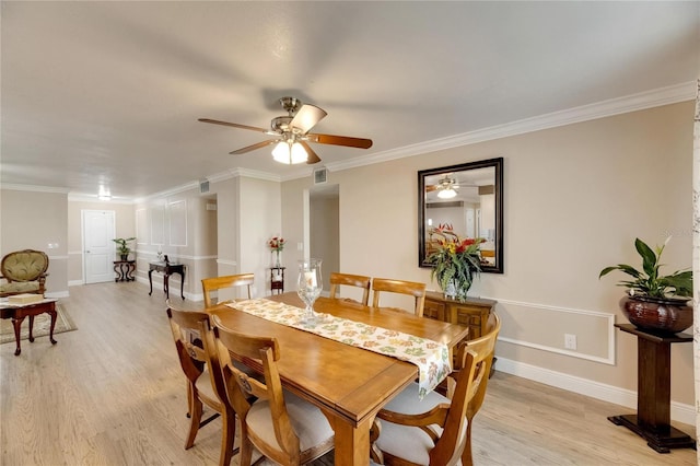 dining area with light wood-type flooring, ornamental molding, and ceiling fan