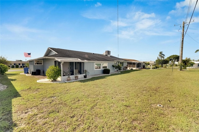 back of property with a sunroom and a yard