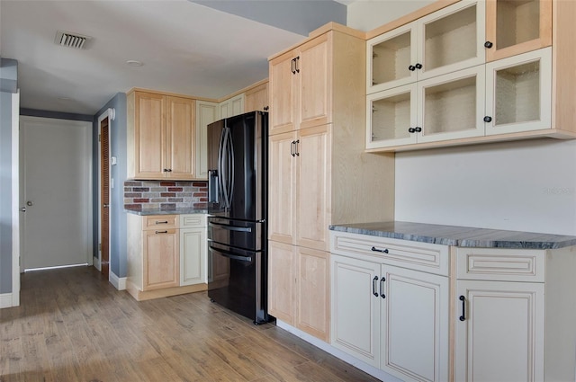 kitchen with black fridge, light hardwood / wood-style flooring, and light brown cabinets