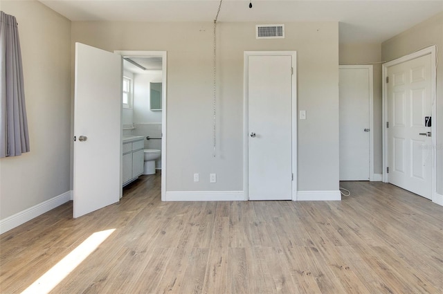 unfurnished bedroom featuring light hardwood / wood-style flooring and ensuite bathroom