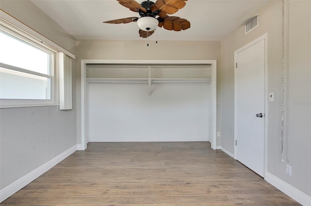 unfurnished bedroom with light hardwood / wood-style floors, ceiling fan, and a closet