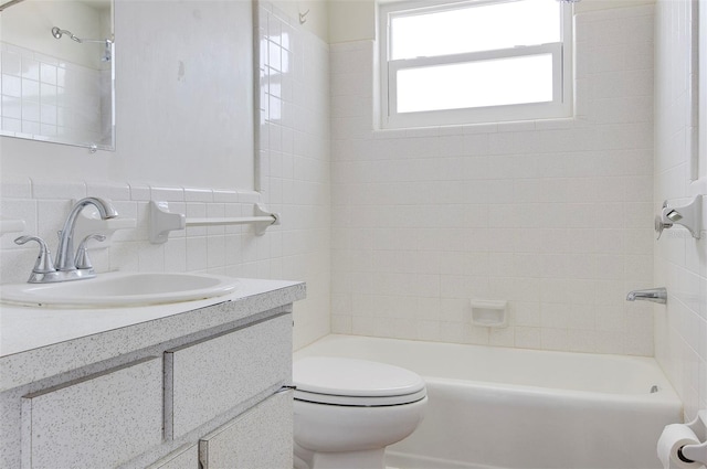 full bathroom with tile walls, vanity, toilet, and tiled shower / bath