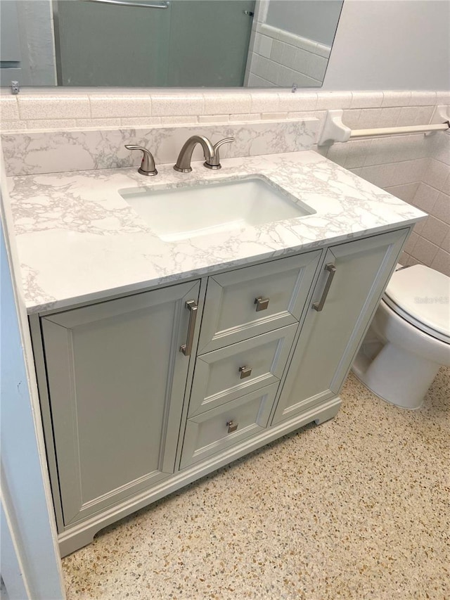 6000 2nd St E Unit 6, St Pete Beach, FL 33706 - bathroom featuring vanity, tile walls, toilet, and wainscoting