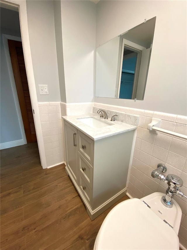 6000 2nd St E Unit 6, St Pete Beach, FL 33706 - bathroom featuring tile walls, wainscoting, wood finished floors, and vanity