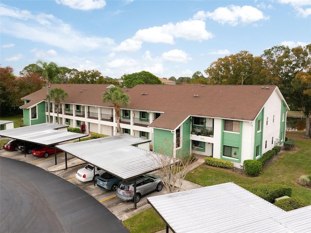 rear view of property with a balcony and a carport