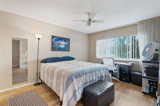 bedroom featuring ceiling fan, a textured ceiling, and light hardwood / wood-style flooring