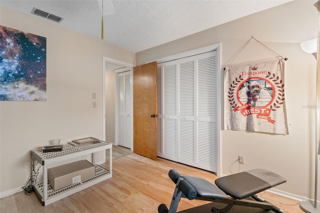 workout room with a textured ceiling and hardwood / wood-style floors