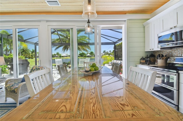 dining area with wooden walls and wooden ceiling