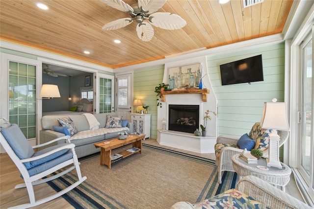 living room featuring wooden ceiling, ceiling fan, and plenty of natural light