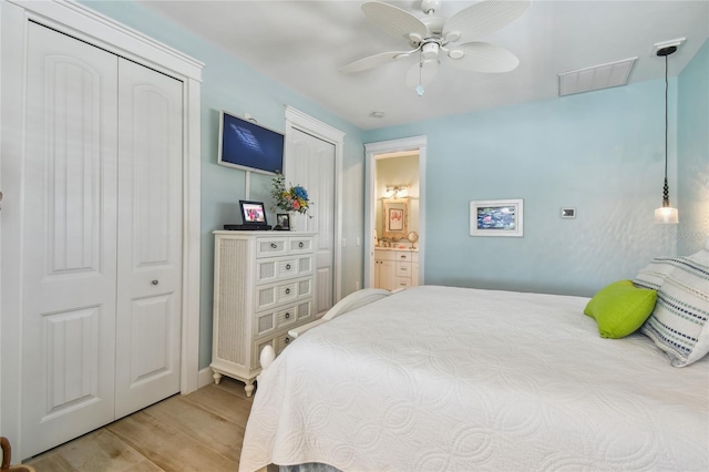 bedroom featuring ceiling fan, light wood-type flooring, and ensuite bath