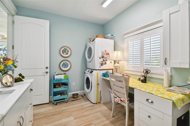 office featuring light hardwood / wood-style floors and stacked washer / dryer