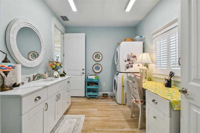 bathroom featuring vanity, hardwood / wood-style floors, and stacked washing maching and dryer