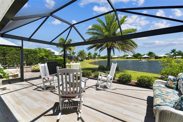 wooden terrace featuring glass enclosure, a water view, and a patio area