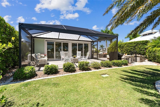 back of property featuring a patio, a yard, and glass enclosure