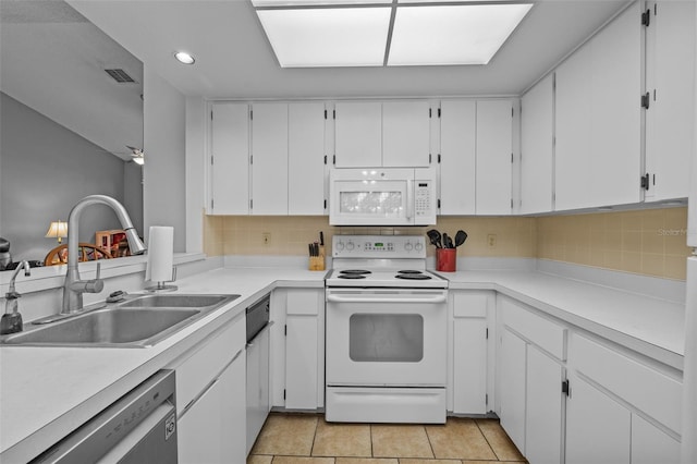 kitchen with tasteful backsplash, sink, white cabinets, white appliances, and light tile patterned floors