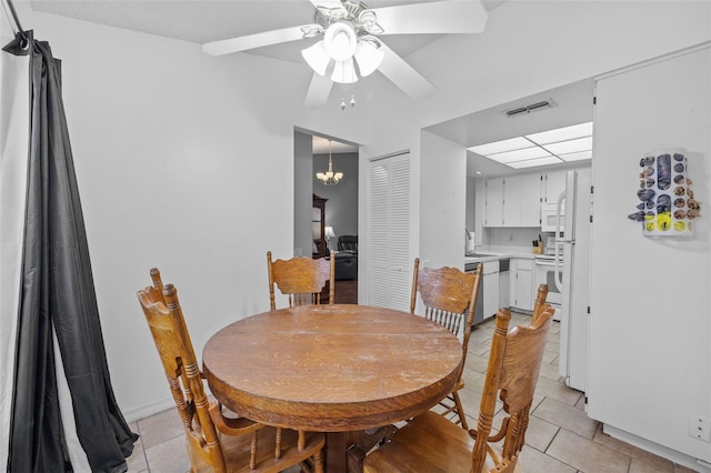 tiled dining area with ceiling fan with notable chandelier and sink