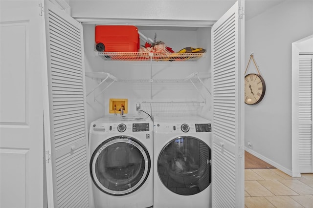 washroom with washing machine and dryer and light tile patterned floors