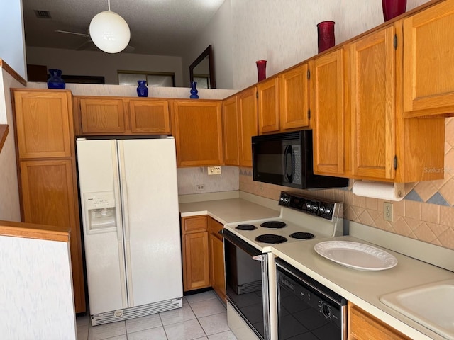 1873 Mazo Mnr Unit T2, Lutz, FL 33558 - kitchen featuring black appliances, light countertops, decorative backsplash, light tile patterned flooring, and a sink