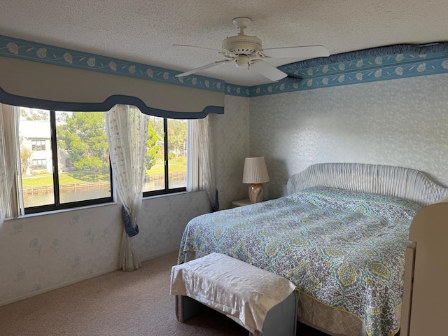 carpeted bedroom with ceiling fan and a textured ceiling