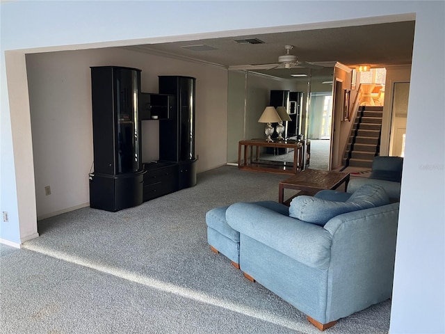 carpeted living room with crown molding and ceiling fan