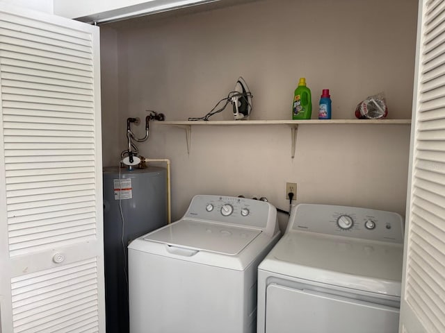 clothes washing area with washer and dryer and water heater