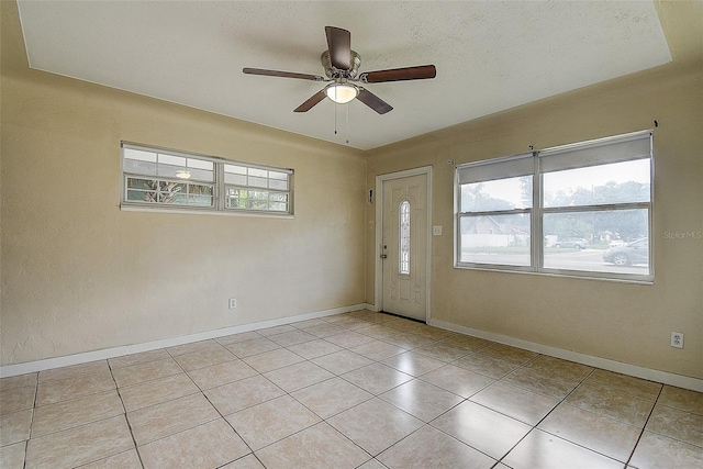 tiled foyer featuring ceiling fan and a textured ceiling