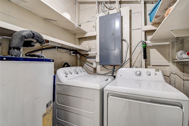 clothes washing area featuring water heater, electric panel, and washer and clothes dryer