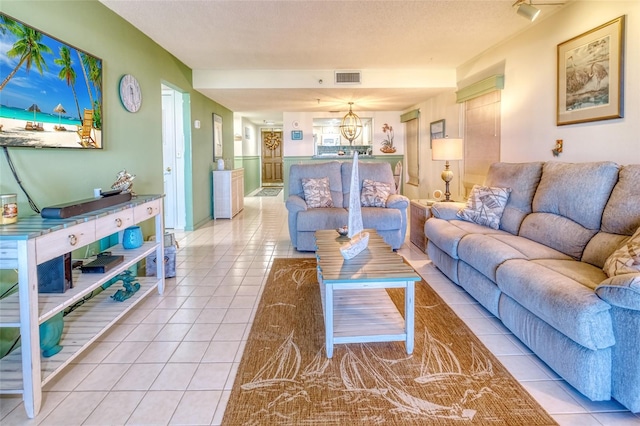 living room with a textured ceiling and light tile patterned floors