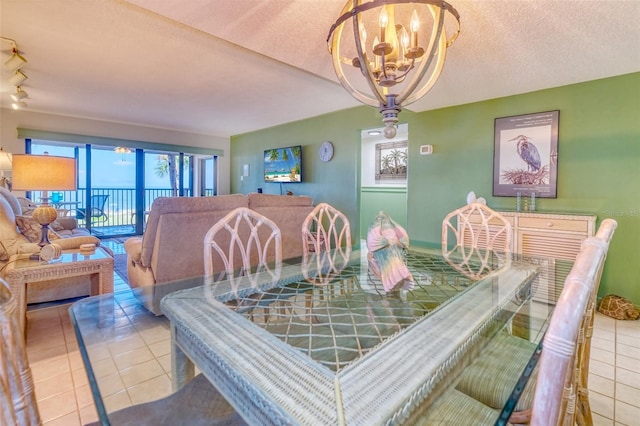 dining area featuring a textured ceiling, a chandelier, light tile patterned flooring, and rail lighting