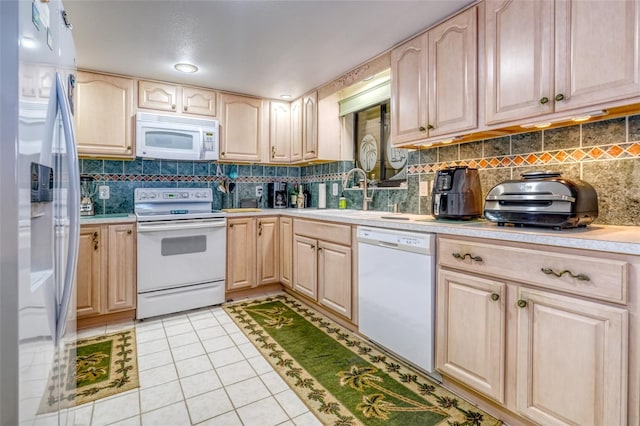 kitchen with light brown cabinets, light tile patterned floors, backsplash, sink, and white appliances