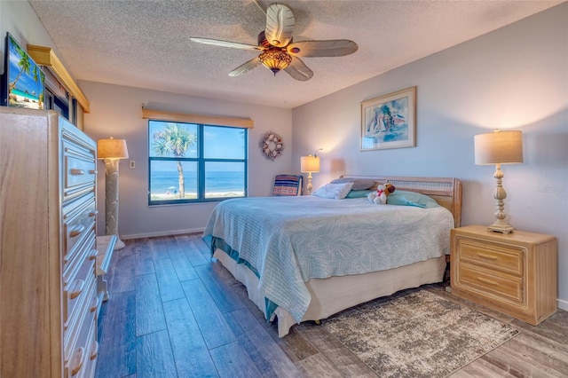 bedroom featuring a textured ceiling, hardwood / wood-style flooring, and ceiling fan