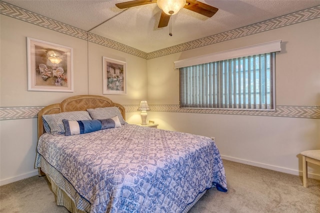 carpeted bedroom with ceiling fan and a textured ceiling