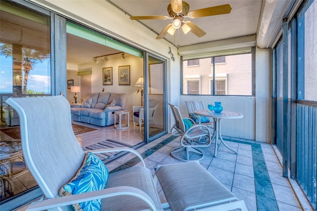 sunroom / solarium featuring track lighting and ceiling fan