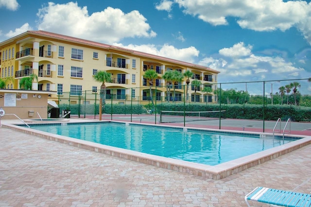 view of swimming pool featuring tennis court