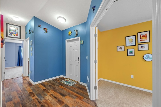 entryway featuring vaulted ceiling, a textured ceiling, and dark wood-type flooring