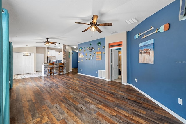 unfurnished living room with ceiling fan and dark wood-type flooring