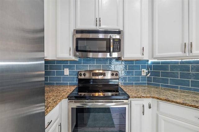 kitchen featuring backsplash, dark stone countertops, white cabinetry, and stainless steel appliances