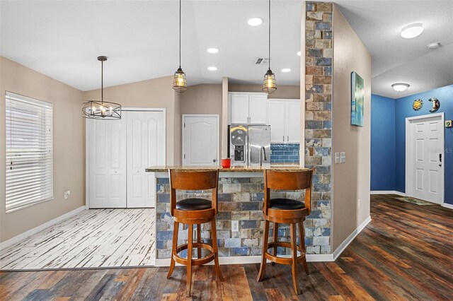 kitchen with stainless steel fridge, dark hardwood / wood-style flooring, light stone counters, and white cabinets