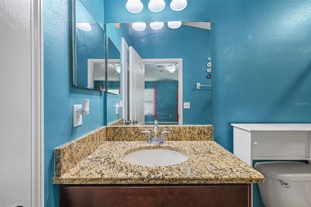 bathroom with ceiling fan, vanity, and toilet