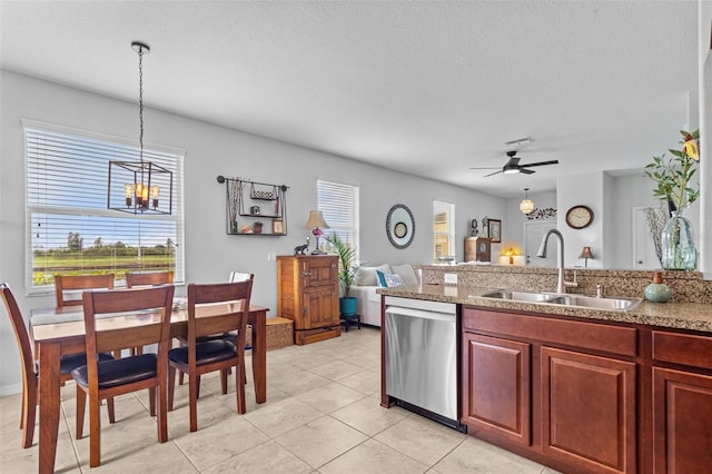 kitchen with ceiling fan with notable chandelier, sink, hanging light fixtures, stainless steel dishwasher, and a textured ceiling