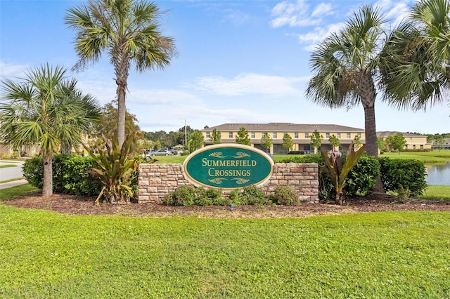 community sign with a yard and a water view