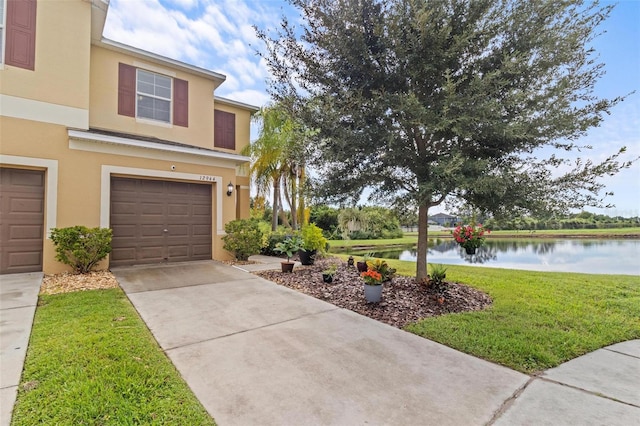 view of front of house featuring a water view, a garage, and a front lawn