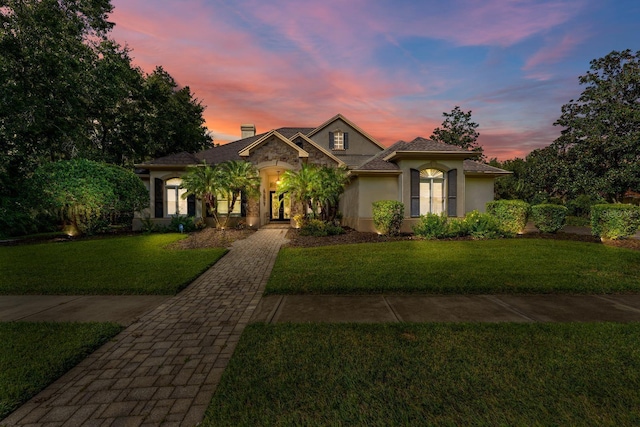 mediterranean / spanish-style house with a front yard and stucco siding