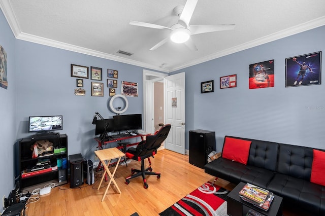 office space featuring crown molding, visible vents, a ceiling fan, and wood finished floors