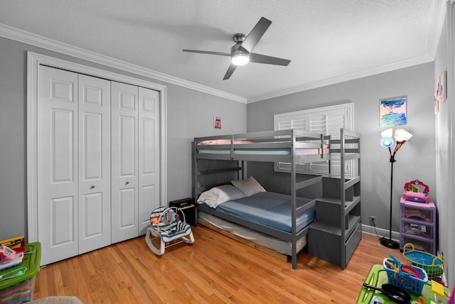 bedroom featuring crown molding, a closet, a textured ceiling, and wood finished floors