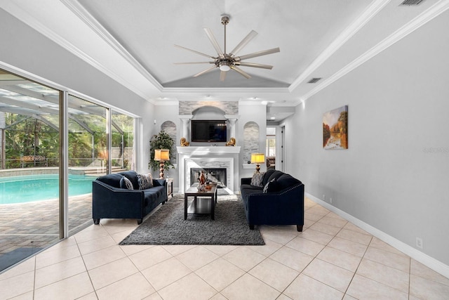 living area with crown molding, a raised ceiling, light tile patterned floors, and a ceiling fan