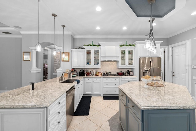 kitchen featuring white cabinets, a sink, stainless steel appliances, and custom range hood