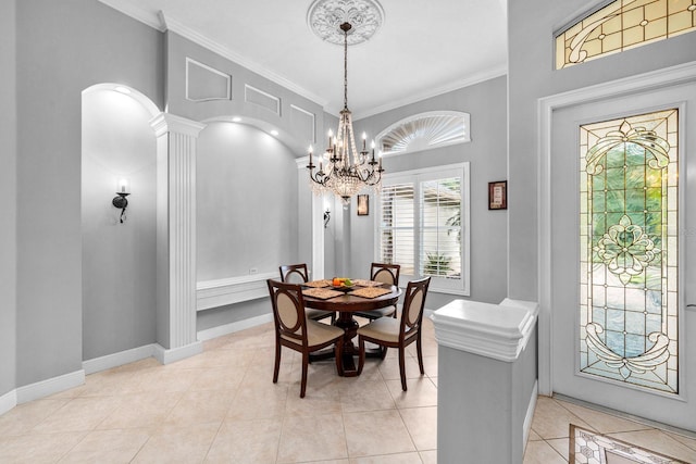 dining room with light tile patterned flooring, a chandelier, baseboards, ornate columns, and ornamental molding